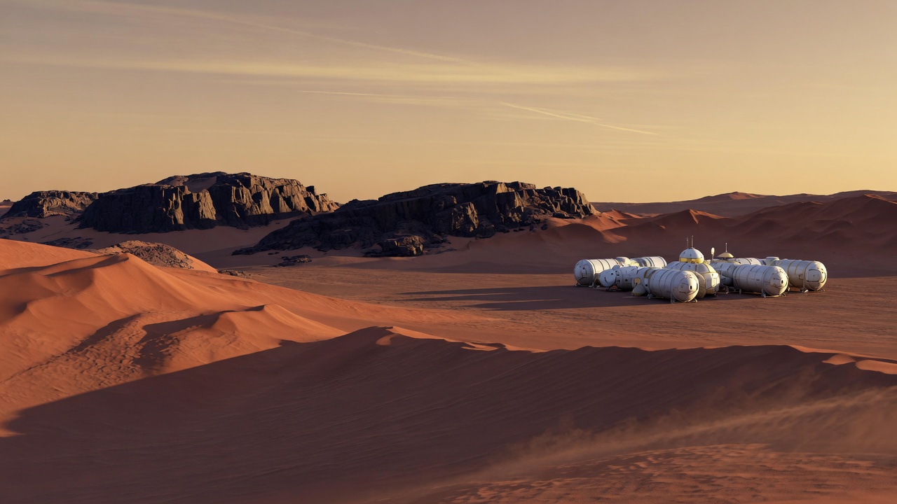 Rust-red Martian dunes at late afternoon, a small cluster of habitat modules in the distance.